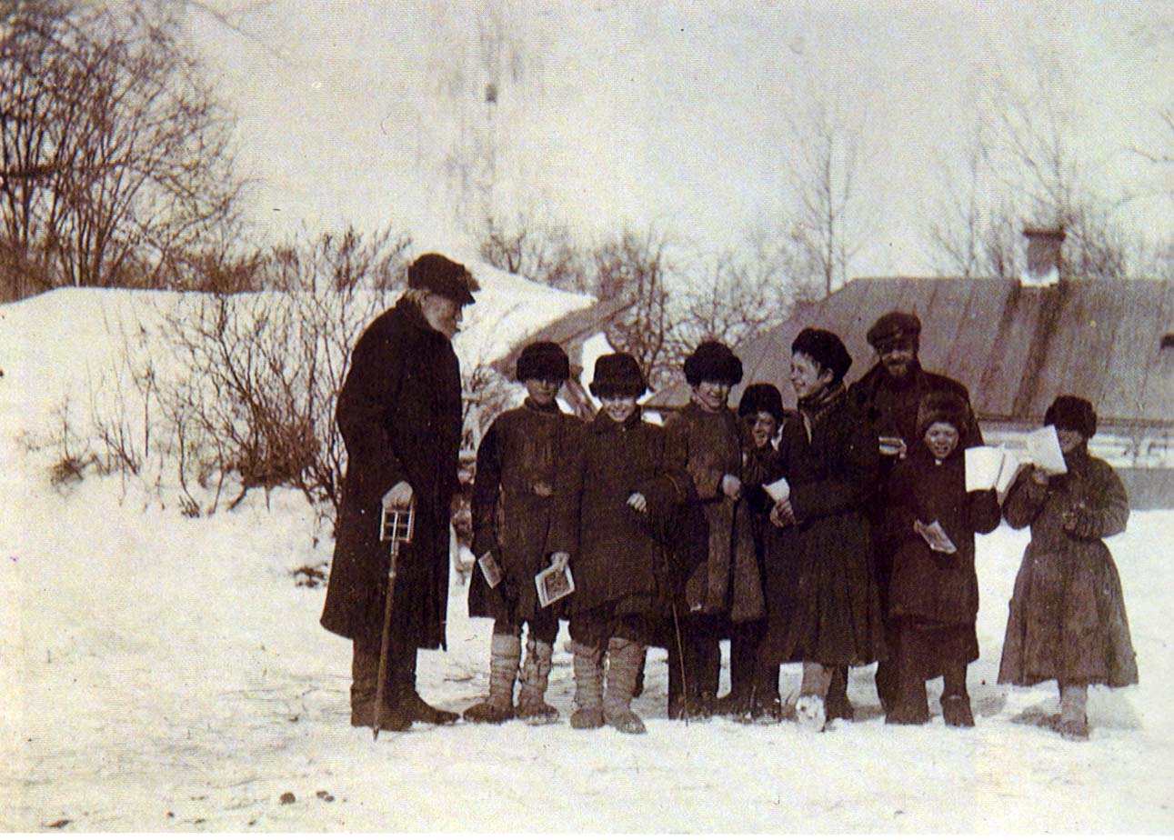 15	Л.Н. Толстой и Н.Н. Гусев (справа) с крестьянскими ребятами. Ясная поляна. Фотография А.Л. Толстой. 1908 г.